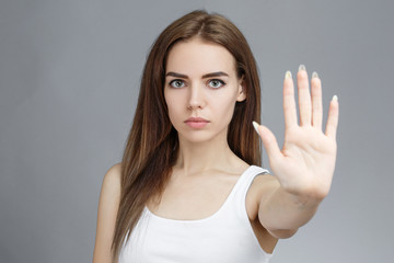 Young woman showing stop with her palm.