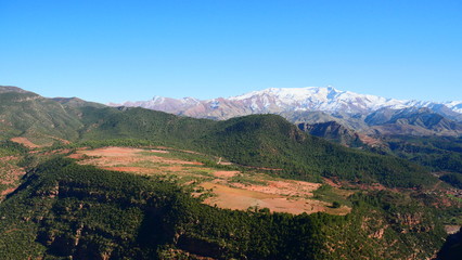 Fototapeta premium Bright landscape of Morocco, breathtaking curves of mountains, stunning combination of hills & farm land,inadvertent distribution of houses & huts, raw impression of pure nature.
