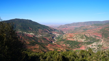 Naklejka premium Bright landscape of Morocco, breathtaking curves of mountains, stunning combination of hills & farm land,inadvertent distribution of houses & huts, raw impression of pure nature.