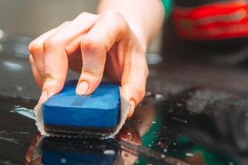 An employee of the car wash thoroughly washes conducts detaling and applies protective equipment to...