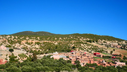 Obraz premium Bright landscape of Morocco, breathtaking curves of mountains, stunning combination of hills & farm land,inadvertent distribution of houses & huts, raw impression of pure nature.