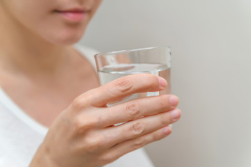 healthy beautiful young woman holding a glass of water. clean drinking water in a clear glass in your hands