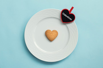 Valentines day, pink plate, heart shaped cookies, on blue background, valentines day concept, flat lay