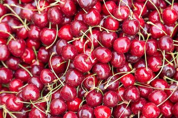 Organic market fresh cherry layed out in the marketpace. Fruit close-up background.