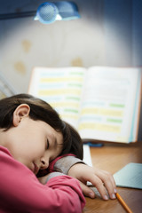Obraz na płótnie Canvas Little asian girl fell asleep at school homework.