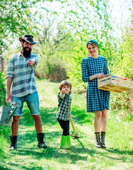 Happy family: mother, father, children son on spring garden background. Family gardening in the backyard garden. Happy family having fun at countryside. Happy family in vegetable garden. Earth day.