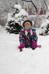 Fototapeta na wymiar portrait caucasian Pretty little girl in modern winter clothes playing in the snow and enjoying winter