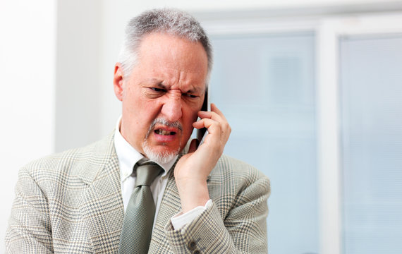 Portrait of an angry businessman yelling at phone