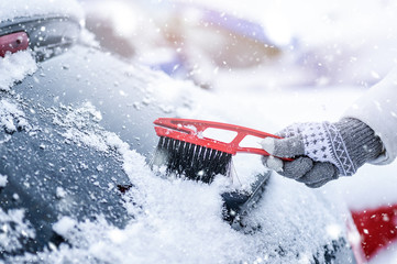 Woman cleaning snow from windshield, Scraping frozen ice glass. Winter car clean front windows.