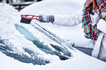 Woman cleaning snow from windshield, Scraping frozen ice glass. Winter car clean front windows. - obrazy, fototapety, plakaty
