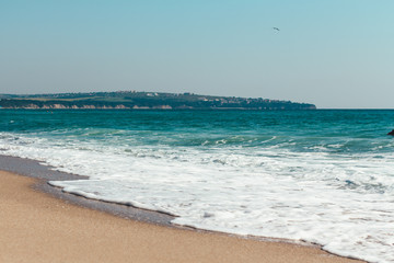 Fototapeta na wymiar Deserted beach Sea waves overlook the sandy shore Summer background