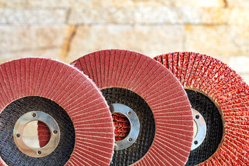Set of grinding abrasive emery discs for grinding of the metal, wood and stone on background of golden sandstone. - obrazy, fototapety, plakaty