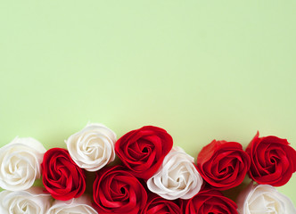 Red and white roses on a green background. Festive background for Valentine's day