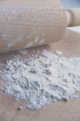 flour on wooden board and rolling pin
