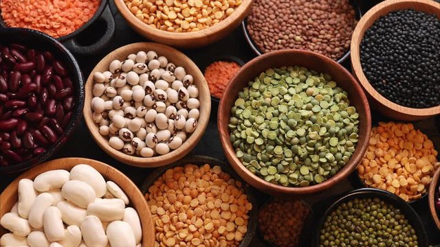 Legumes, a set consisting of different types of beans, lentils and peas on a black background, top view, close up, 4k. The concept of healthy and nutritious food
