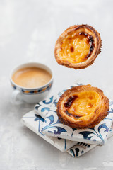 typical portuguese egg tart pastel de nata with cup of coffee on ceramic background