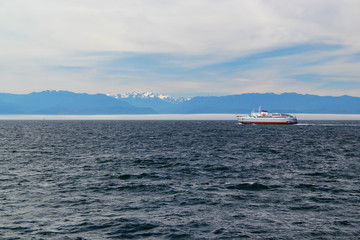 Fototapeta premium Dark sea with cruise ship / in the Background white mountains