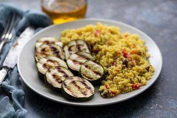 tabbouleh and grilled courgette on white plate on ceramic background