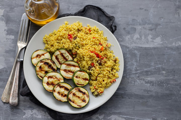 tabbouleh and grilled courgette on white plate on ceramic background