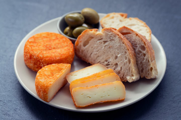 appetizer cheese with bread and olives on dish