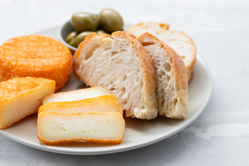 appetizer cheese with bread and olives on dish