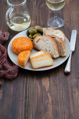 appetizer cheese with bread and olives on dish