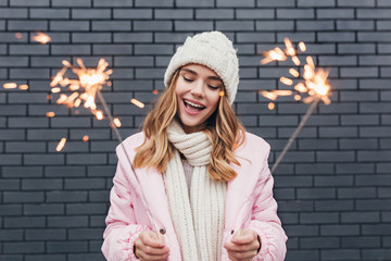 Beautiful girl in white winter attire celebrating holidays. Outdoor shot of smiling romantic lady...
