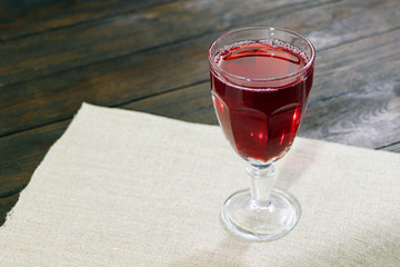 Glass of red wine on a wooden table.