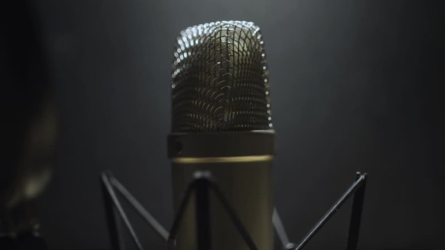 Tilt up on Voice Over microphone in a dark studio recording room