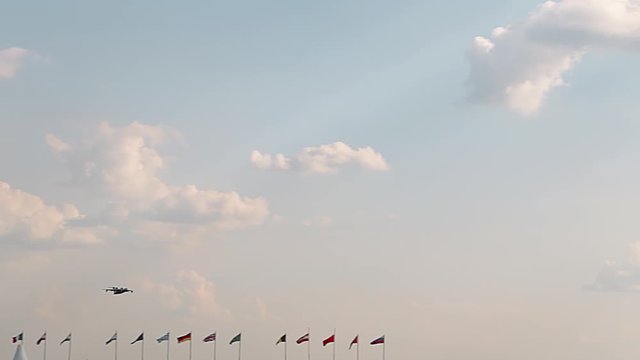 Big passenger plane in the blue sky. Country flags. A general plan. Aerobatic figures. Airshow. 17 seconds