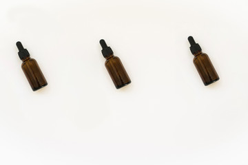 Homemade cosmetics glass bottles pattern. Natural medicine concept. Jars with essential oil isolated on a white background. Flat lay or top view.
