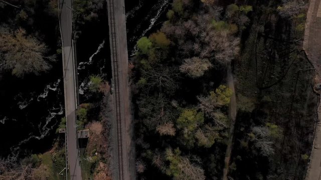 Train Tracks Crossing River Near Nature Trail In Woods Top Down Aerial Drone Shot
