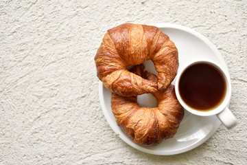 breakfast with croissant with cup of tea on a textured background