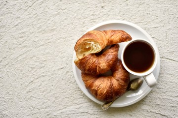 breakfast with croissant with cup of tea on a textured background