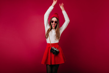Magnificent white woman in good mood dancing with camera. Lovable dark-haired female photofrapher expressing happiness.