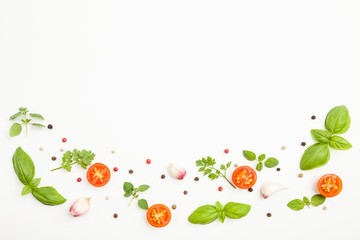 Fresh cherry tomatoes, oregano, basil, parsley, garlic, peppercorns on white background. Top...