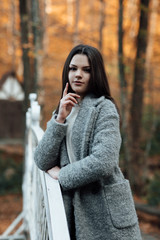  fresh faced girl with a beautiful face. Portrait of smiling young woman. Portrait of a young girl with clean skin and a natural color hair. The girl relies on the handrail on nature background