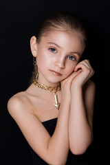 Obraz premium Closeup portrait of glamour little girl with beautiful visage. The beautiful girl on a black background.