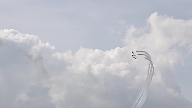 3 fighter jets in the blue sky. A general plan. Aerobatic figures. Airshow. 8 seconds