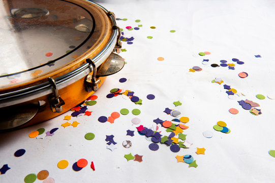 Pandeiro, traditional samba instrument, used in the Brazilian carnival. White background, paper confetti. Seen from above. Space for text. Horizontal.