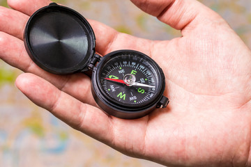 Person holds a compass on the palm. Concept of travel, navigation, positioning.