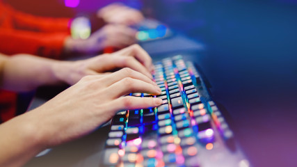 Professional cyber video gamer studio room with personal computer armchair, keyboard for stream in neon color blur background, soft focus