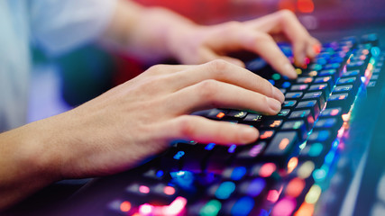 Professional gamer playing tournaments online video games computer with headphones, red and blue