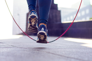 Close up of an athletic person's feet jumping rope outdoor - Powered by Adobe