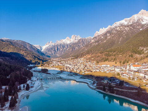 The view of Auronzo and the frozen lake Santa Katerina, Dolomites, Italy. Drone aerial photo
