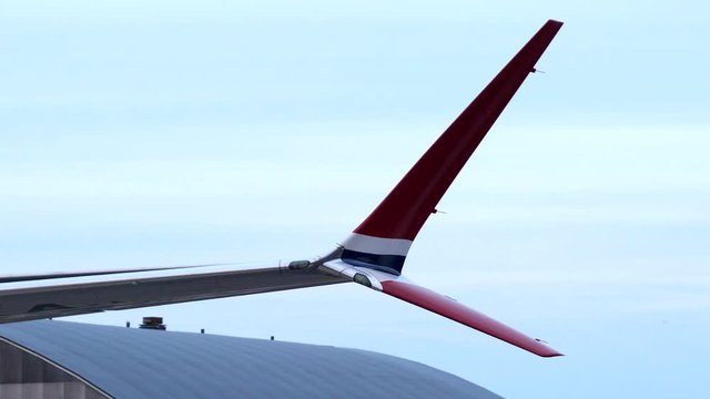 Red colored split tip winglet of airliner, isolated close up