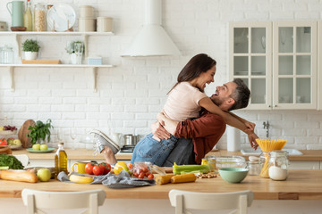 Happy husband and wife having fun during cooking