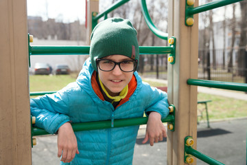 A smiling boy with glasses on playground, Russia