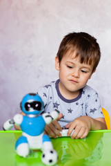 Little boy is playing with robot. Robot for children. Smart toy