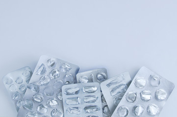 Empty silver packaging for medicines, pills on gray background.